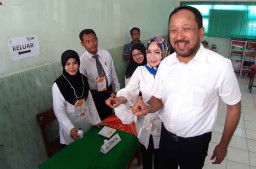 Kompak Berbaju Putih, Bupati Ipong dan Istri Nyoblos di TPS 004