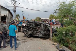 Tertabrak Kereta Api di Surabaya, Mobil Terlempar Timpa Warkop, Pengemudi Tewas