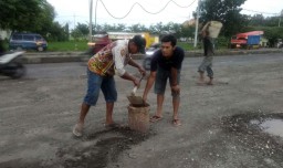 Potret Warga Menambal Lubang Jalan Trans Nasional di Mojokerto