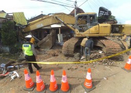 Rem Blong, Backhoe 'Lompat' dari Truk yang Memuatnya, 9 Rumah Rusak